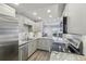 Bright kitchen features stainless appliances, stone countertops, gray cabinets, and flows into an open-concept living space at 4929 W 73Rd Ave, Westminster, CO 80030
