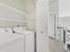 Bright laundry room features a washer, dryer, overhead shelving, and hallway access at 4929 W 73Rd Ave, Westminster, CO 80030
