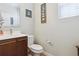 Powder room with cherry vanity, modern fixtures, toilet, light walls and decor at 9682 Dunning Cir, Highlands Ranch, CO 80126