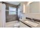 Modern bathroom showcases sleek gray tile, bathtub, vanity with sink, and stylish fixtures at 1261 S Harrison St, Denver, CO 80210