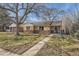 Charming single story brick home with a manicured lawn, mature trees, and inviting walkway at 1261 S Harrison St, Denver, CO 80210