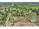 Scenic aerial view features a home, grassy field, and storage building, bordered by suburban homes and fields at 6351 S Andes Pl, Centennial, CO 80016