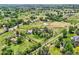 Wide aerial shot showcasing the home and property featuring a barn, lush fields, and mature trees at 6351 S Andes Pl, Centennial, CO 80016