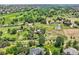 Wide aerial view of large acreage including grassy fields, mature trees, and multiple homes nearby at 6351 S Andes Pl, Centennial, CO 80016