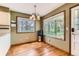 Sunlit dining area features hardwood floors, and large windows overlooking the lush backyard at 6351 S Andes Pl, Centennial, CO 80016