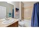 Functional bathroom features a tub/shower combination with blue curtain, and a neutral countertop vanity sink at 16110 Poplar St, Brighton, CO 80602