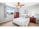 Bright bedroom featuring a ceiling fan, comfortable bed, and a large window with a view at 16110 Poplar St, Brighton, CO 80602