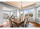 Inviting dining area featuring a coffered ceiling, chandelier, wood table set, and natural light from large windows at 16110 Poplar St, Brighton, CO 80602