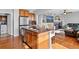 Open kitchen featuring granite countertops, an island with seating, stainless steel appliances and hardwood floors at 16110 Poplar St, Brighton, CO 80602