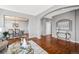 Open-concept space with hardwood floors, a dining area with chandelier, and elegant glass console table at 16110 Poplar St, Brighton, CO 80602