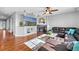 Cozy living room highlighting hardwood floors, a fireplace, a large television, and a leather sectional at 16110 Poplar St, Brighton, CO 80602