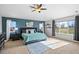 Bright main bedroom with large windows, blue accent wall, and stylish furniture at 16110 Poplar St, Brighton, CO 80602
