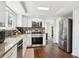 Well-lit kitchen boasting stainless steel appliances, granite countertops, and sleek wood flooring at 4 Mountain Ash, Littleton, CO 80127