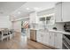 Modern kitchen boasts white cabinets, stainless appliances, quartz countertops, and seamless access to outdoor space at 4 Mountain Ash, Littleton, CO 80127