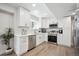 Well-lit modern kitchen with stainless steel appliances, white cabinets, and wood-style flooring at 4 Mountain Ash, Littleton, CO 80127