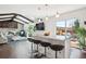 Open-concept living space with island, bar seating, vaulted ceiling, and wood beam accents at 4 Mountain Ash, Littleton, CO 80127