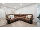 Spacious living room featuring a comfortable brown leather couch, modern flooring, and neutral wall color at 4 Mountain Ash, Littleton, CO 80127