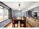 Dining room with hardwood floors, large windows, and a view into an adjoining living space at 11210 Parliament Way, Parker, CO 80138