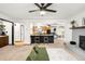 Bright living room with brick fireplace, open floorplan to kitchen, and modern décor at 11210 Parliament Way, Parker, CO 80138