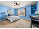 Bright bedroom with blue walls, a ceiling fan, and built-in shelving by the window at 1114 Lasnik St, Erie, CO 80516