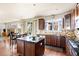 Modern kitchen featuring dark wood cabinets, granite countertops, stainless steel appliances, and a central island at 1114 Lasnik St, Erie, CO 80516