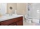 Bathroom featuring a single sink vanity with cherry wood cabinets, a toilet and a tub with shower at 16525 Sanford St, Mead, CO 80542