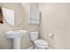 A sleek bathroom with a white pedestal sink, toilet, and a minimalist medicine cabinet for essential storage at 16525 Sanford St, Mead, CO 80542