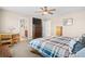 This bedroom is decorated with a plaid comforter on the bed, ceiling fan, wooden desk, and natural lighting at 16525 Sanford St, Mead, CO 80542