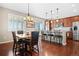 Inviting dining area featuring a wooden table, modern light fixture, and seamless flow into the kitchen at 16525 Sanford St, Mead, CO 80542