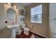 Small bathroom with pedestal sink, toilet, and wood floor at 1035 Cryolite Pl, Castle Rock, CO 80108