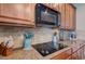 Kitchen cooktop with granite countertops and wooden cabinets at 1035 Cryolite Pl, Castle Rock, CO 80108