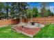 A backyard is landscaped with a mulched area, wooden timbers, river rock, mature trees and wood fence at 1821 E Kettle Ave, Centennial, CO 80122