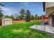 Expansive backyard with a lush lawn, stained wood fence, storage shed, mature trees and a concrete patio at 1821 E Kettle Ave, Centennial, CO 80122
