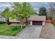 Exterior front elevation of a home with mature tree, driveway, stone accents and an attached garage at 1821 E Kettle Ave, Centennial, CO 80122