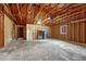 A spacious unfinished garage showcases wooden beams, a window, and a door leading to the rest of the house at 1821 E Kettle Ave, Centennial, CO 80122