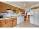 Charming kitchen featuring wood cabinets, white appliances, and a view to the stairs at 1821 E Kettle Ave, Centennial, CO 80122