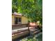 Backyard deck with a wooden bench, surrounded by greenery and trees at 8705 W 86Th Dr, Arvada, CO 80005