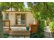 Backyard deck with a wooden bench, steps, greenery, trees, and view into main floor at 8705 W 86Th Dr, Arvada, CO 80005