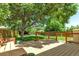 Backyard deck with a wooden bench, green grass, and surrounding trees at 8705 W 86Th Dr, Arvada, CO 80005