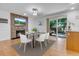 Dining room featuring a stone fireplace, glass table, and sliding glass door to backyard at 8705 W 86Th Dr, Arvada, CO 80005