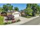 Inviting home exterior featuring a well-maintained yard,solar panels, garage, and a beautiful flowering garden at 8705 W 86Th Dr, Arvada, CO 80005