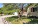 Well-maintained front yard with mature tree and attractive landscaping adding curb appeal at 8705 W 86Th Dr, Arvada, CO 80005