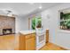 Bright kitchen with white appliances and natural light with an adjacent living area with fireplace at 8705 W 86Th Dr, Arvada, CO 80005