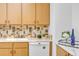 Well-maintained kitchen with light wooden cabinets, backsplash, and modern appliances at 8705 W 86Th Dr, Arvada, CO 80005