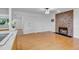 Open living area with hardwood floors and a stone fireplace, leading to kitchen at 8705 W 86Th Dr, Arvada, CO 80005