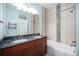 Bathroom featuring double sinks, granite countertops, a soaking tub, and tile accents at 4225 W 30Th Ave, Denver, CO 80212