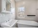 Elegant bathroom featuring a soaking tub, pedestal sink, and natural light from the window at 4225 W 30Th Ave, Denver, CO 80212