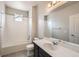 A bathroom with white tiling around the tub and shower combo next to a black vanity and large mirror at 9269 Garnett St # C, Arvada, CO 80007