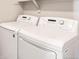 Close-up of a white front-load washer and dryer set in the laundry room, offering convenience and efficiency at 9269 Garnett St # C, Arvada, CO 80007