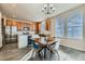 Bright eat-in kitchen featuring wood cabinets, modern appliances, and stylish tile flooring at 441 Baler Ct, Brighton, CO 80601